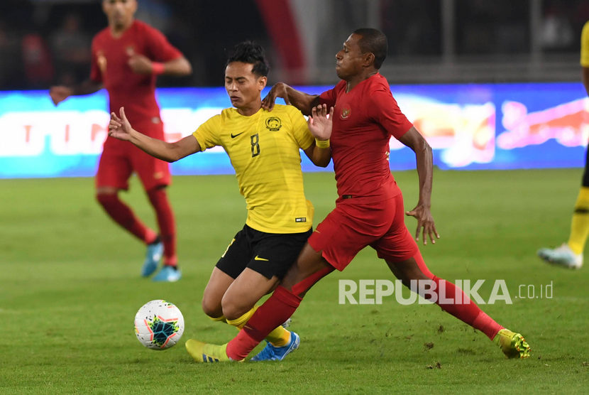 Pemain Timnas Indonesia Yustinus Paew (kanan) berebut bola dengan pemain Timnas Malaysia Muhamad Nor Azam saat laga perdana Grup G Kualifikasi Piala Dunia 2022 zona Asia di Stadion Utama Gelora Bung Karno, Senayan, Jakarta, Kamis (5/9/2019).