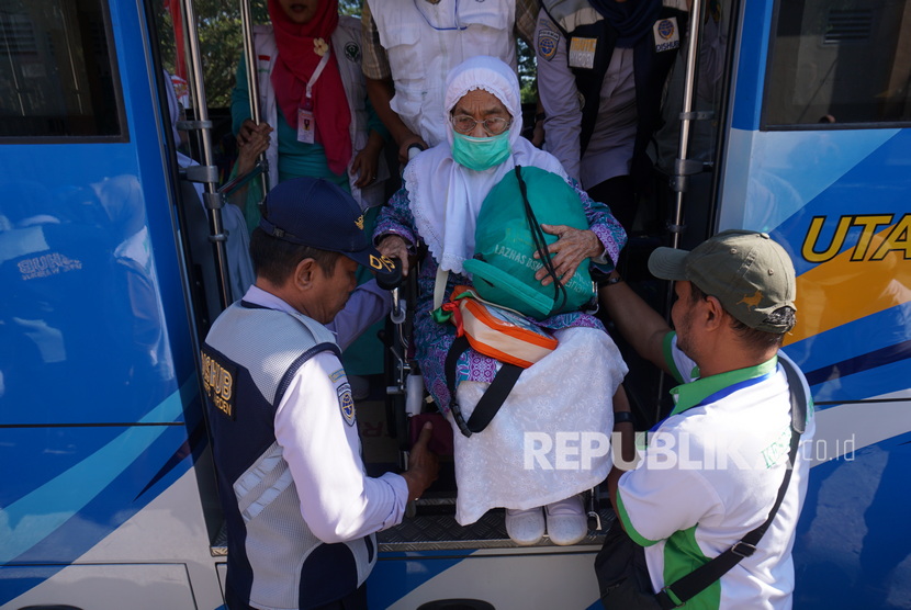 Petugas membantu jamaah haji lansia setibanya di Asrama Haji Transit di Palu, Sulawesi Tengah, Senin (9/9/2019).