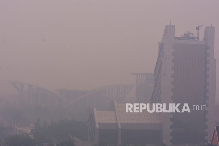 Gedung Perpustakaan Daerah Soeman HS (kiri) dan Menara Bank Riau-Kepri (kanan) tampak samar-samar ketika kabut asap kebakaran hutan dan lahan (Karhutla) menyelimuti Kota Pekanbaru, Riau, Selasa (10/9/2019). 