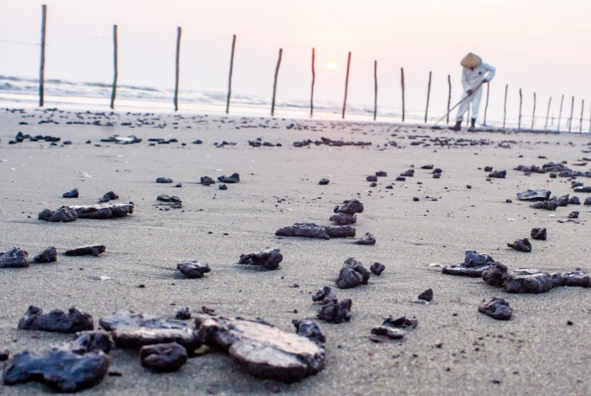 Petugas mengumpulkan ceceran tumpahan minyak mentah di Pantai Sedari, Cibuaya, Karawang, Jawa Barat, Selasa (10/9/2019). 