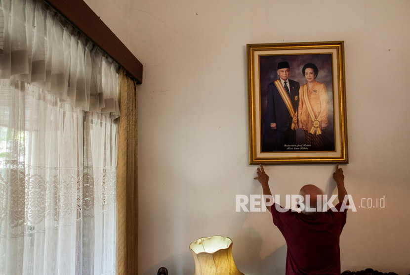 Asisten rumah tangga merapikan foto almarhum Presiden ke-3 Republik Indonesia BJ Habibie dan almarhumah Ibu Hasri Ainun Habibie di rumah milik ibunda RA Habibie di Bandung, Jawa Barat, Kamis (12/9/2019).