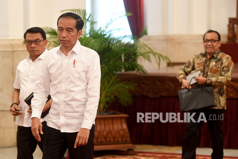 Presiden Joko Widodo (tengah) didampingi Kepala Staf Kepresiden Moeldoko (kiri) dan Mensesneg Pratikno (kanan) berjalan meninggalkan ruangan usai menyampaikan keterangan terkait revisi UU KPK di Istana Negara, Jakarta, Jumat (13/9/2019).