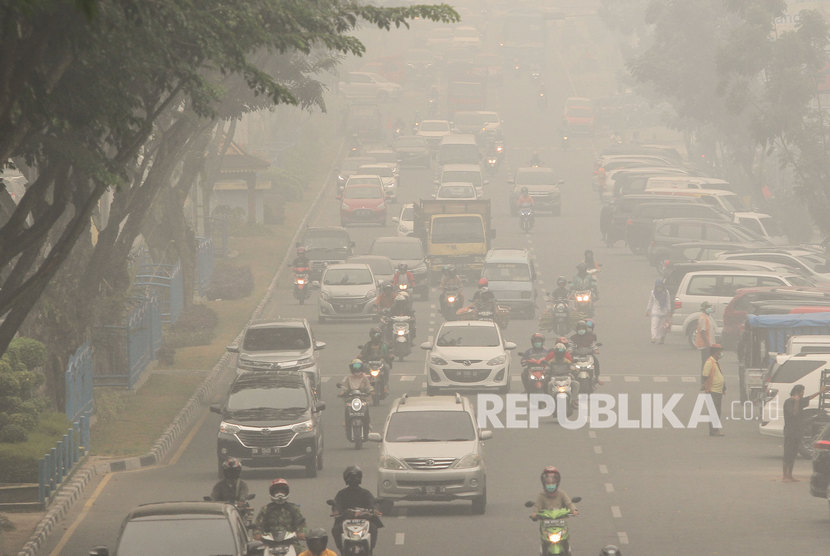 Pengendara kendaraan bermotor menembus kabut asap pekat dampak dari kebekaran hutan dan lahan di Pekanbaru, Riau, Jumat (13/9/2019).