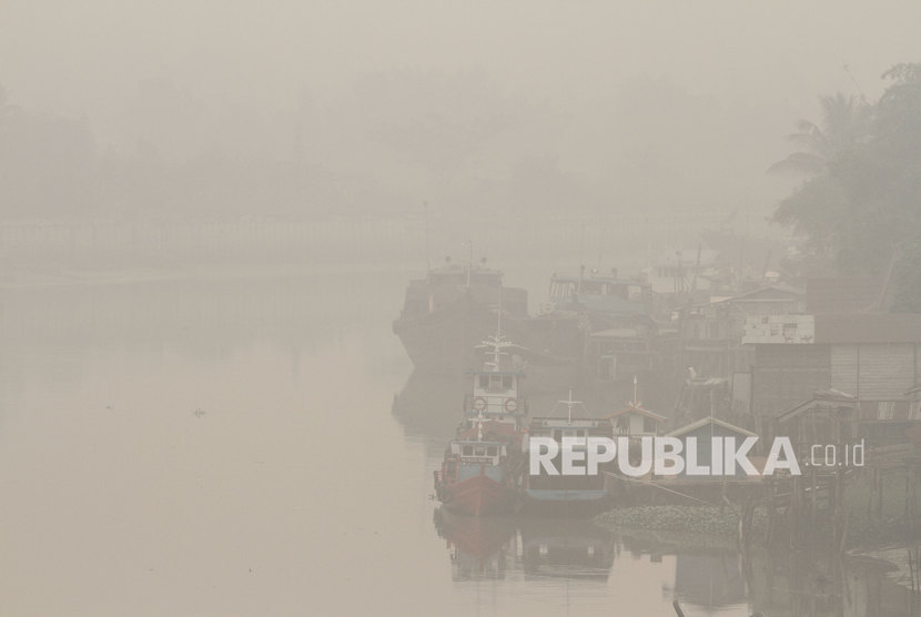 Sejumlah kapal terparkir di pelabuhan rakyat sungai Siak ketika kabut asap pekat dampak dari kebakaran hutan dan lahan menyelimuti Kota Pekanbaru, Riau, Jumat (13/9/2019).