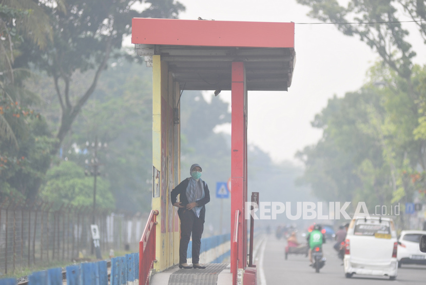 Ilustrasi. Warga menggunakan masker saat beraktivitas di Padang yang diselimuti kabut asap, Sumatera Barat.