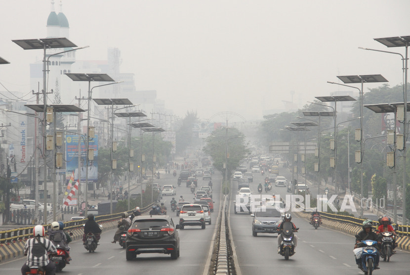 Sejumlah kendaraan bermotor melintas di Fly Over jalan Ahmad Yani yang terpapar kabut asap di Banjarmasin, Kalimantan Selatan, Ahad (15/9/2019)