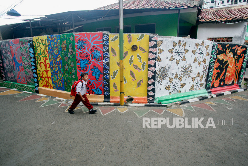Seorang siswa sekolah melintas di samping mural bermotif batik di Jalan Neglasari, Kota Bogor, Jawa Barat, Senin (16/9/2019).