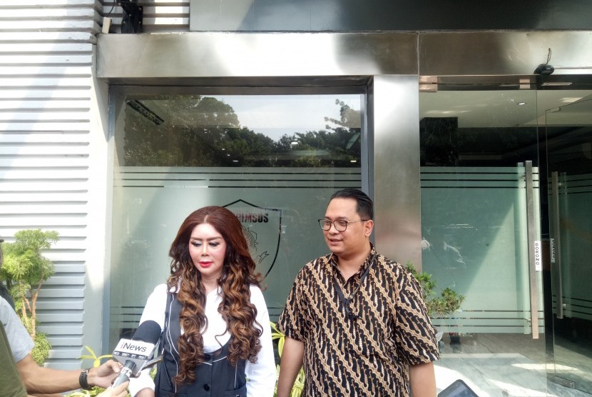 Titi Sumawijaya Empel (kiri) dan kuasa hukumnya Jack Lapian saat akan melakukan pemeriksaan terkait laporannya terhadap pendiri forum diskusi daring terbesar di Indonesia, Kaskus, Andrew Darwis di Ditreskrimsus Polda Metro Jaya, Senin (16/9).