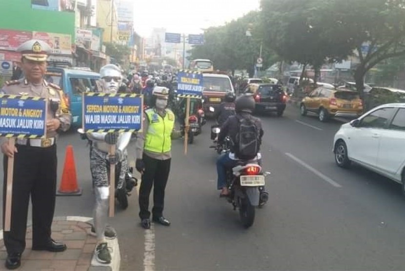 Satuan Lalu Lintas (Satlantas) Polresta Depok melakukan sosialisasi penggunaan jalur lambat untuk kendaraan motor dan angkutan kota (angkot) di Jalan Margonda, Kota Depok, Rabu (18/9). 