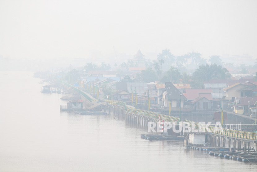 Suasana pemukiman penduduk di tepian Sungai Kapuas yang diselimuti kabut asap pekat di Pontianak, Kalimantan Barat, Rabu (18/9/2019).