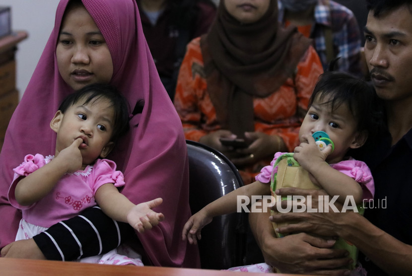 Bayi kembar siam Aqila (kiri) digendong ibunya Silvina Dewi dan Azila (kanan) digendong bapaknya Jayasri saat acara syukuran atas keberhasilan pemisahan bayi kembar siam asal Kendari, Sulawesi Tenggara, di Rumah Sakit Umum Daerah (RSUD) Dr Soetomo, Surabaya, Jawa Timur, Jumat (20/9/2019).