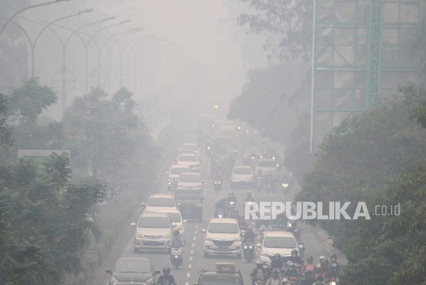 Sejumlah pengendara melintasi jalan yang diselimuti kabut asap sangat pekat di Pontianak, Kalimantan Barat, Jumat (20/9/2019).