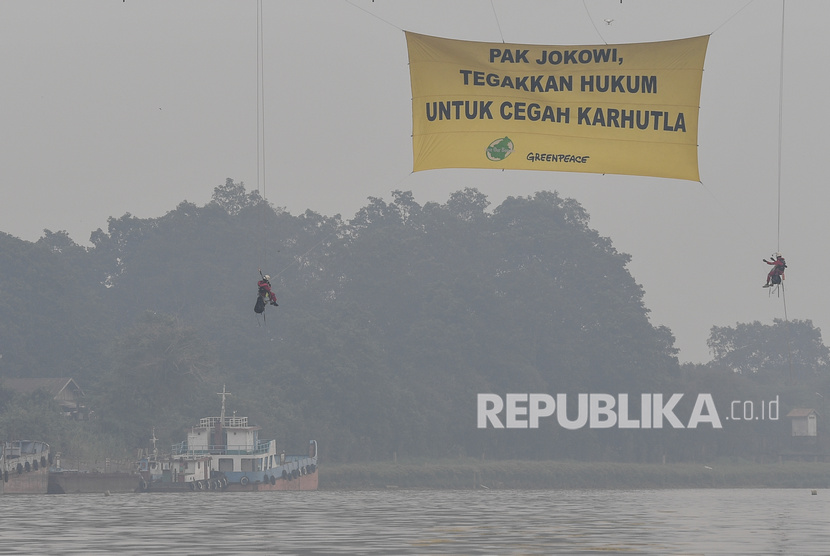 Aktivis lingkungan Greenpeace Indonesia dan Save Our Borneo melakukan aksi pembentangan spanduk raksasa di bawah Jembatan Kahayan, Palangka Raya, Kalimantan Tengah, Ahad (22/9/2019).