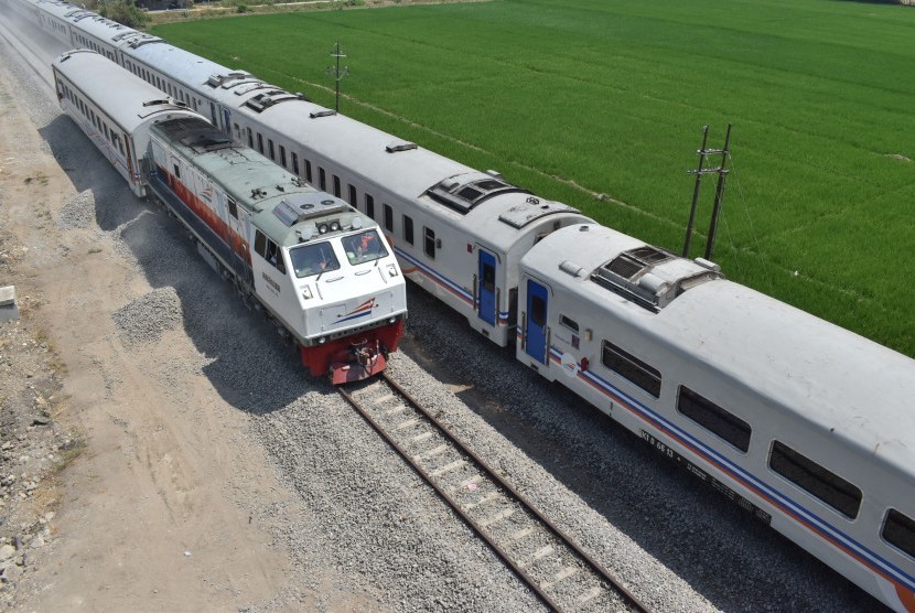 Rangkaian kereta uji beban (kiri) melintasi jalur baru di samping KA 155 Singasari relasi Blitar-Pasar Senen di jalur ganda Kereta Api (KA) di Madiun, Jawa Timur, Selasa (24/9/2019).