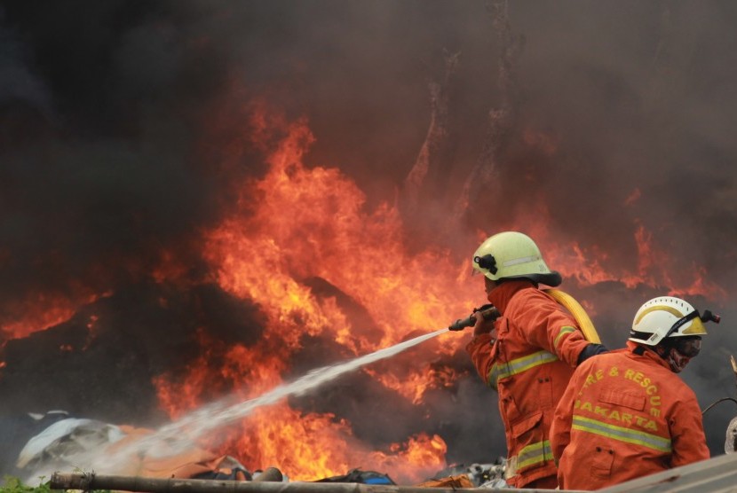 Petugas pemadam kebakaran mencoba memadamkan api yang membakar gudang
