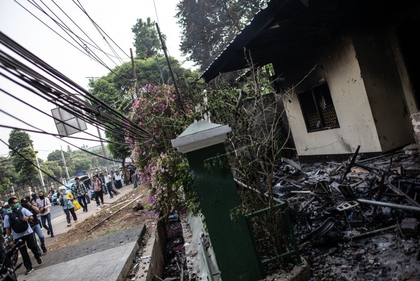 Sejumlah warga berjalan di depan kantor Polisi Subsektor Palmerah yang hangus terbakar pascaunjuk rasa mahasiswa di Jalan Gelora, Senayan, Jakarta, Rabu (25/9/2019).