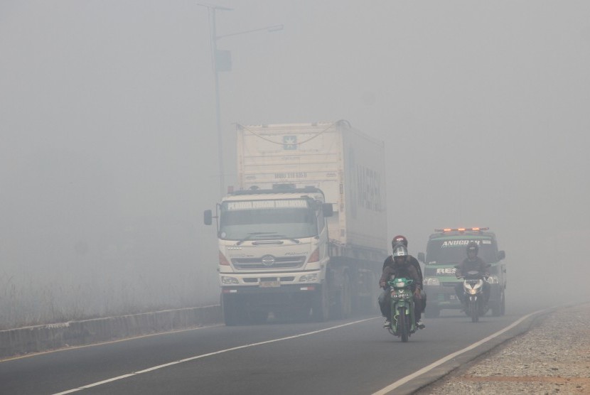 Sejumlah kendaraan bermotor melintas di jalan lingkar selatan yang diselimuti kabut asap pekat di Banjarbaru, Kalimantan Selatan, Rabu (25/9/2019). 