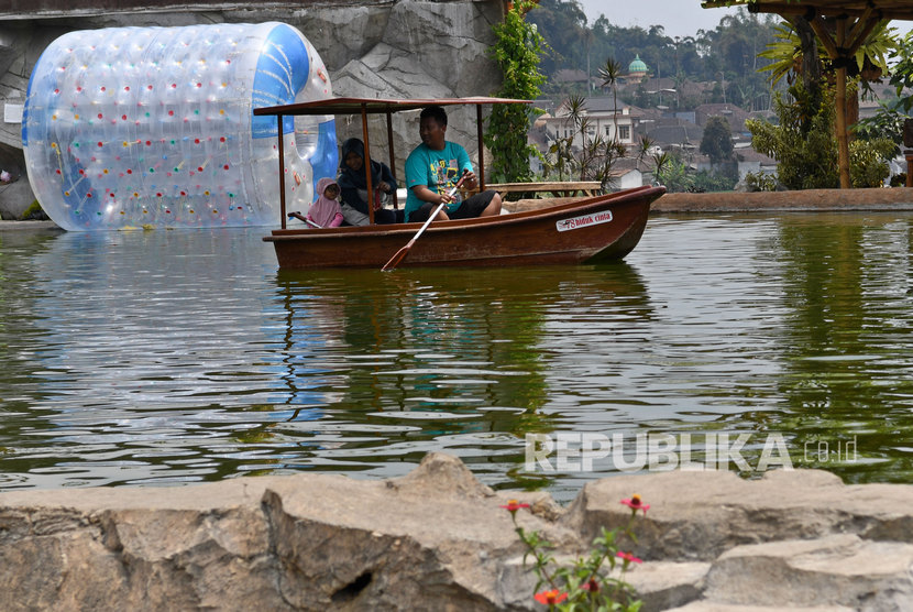Sejumlah wisatawan mengendarai perahu di obyek wisata Kafe Sawah yang dikelola Badan Usaha Milik Desa (BUMDes) Pujon Kidul di Pujon, Kabupaten Malang, Jawa Timur.