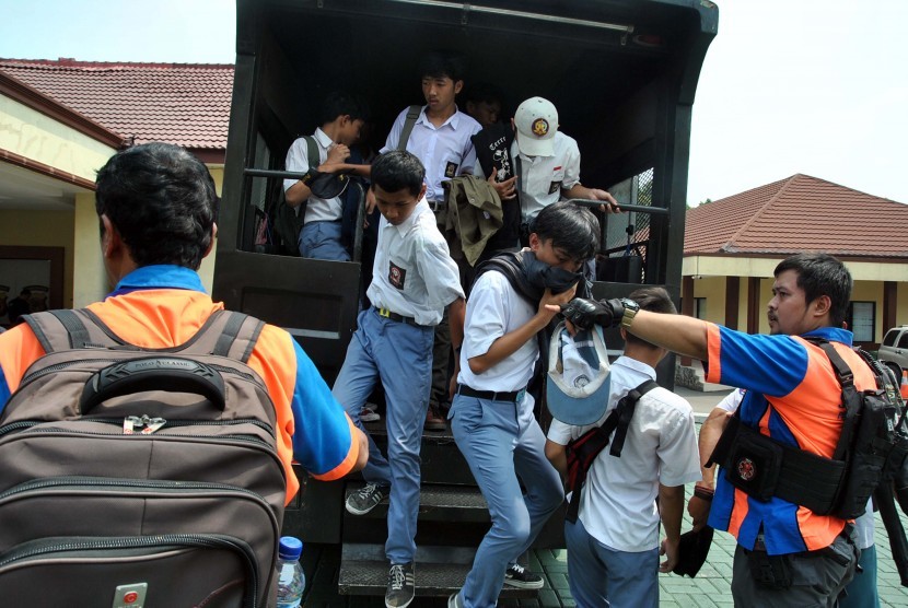 Anggota Satgas Pelajar Kota Bogor menurunkan sejumlah pelajar SMK di halaman Mako Polresta Bogor Kota, Kapten Muslihat, Kota Bogor, Jawa Barat, Senin (30/9/2019).