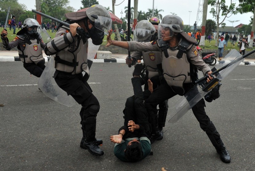 Petugas kepolisian terlibat bentrok dengan mahasiswa (tengah) saat unjuk rasa menolak RUU KUHP dan UU KPK hasil revisi di Kantor DPRD Jambi, Senin (30/9/2019).