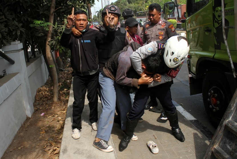 Polisi mengamankan sejumlah pelajar yang turun dari mobil truk saat hendak mengikuti aksi demo, di Bekasi, Jawa Barat, Senin (30/9/2019). 
