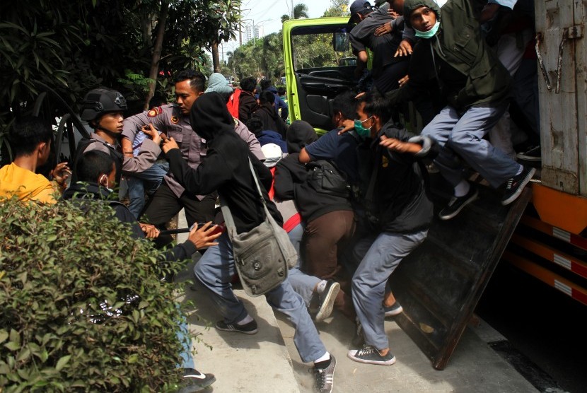 Polisi berusaha menghadang pelajar yang turun dari mobil truk saat hendak mengikuti aksi demo, di Bekasi, Jawa Barat, Senin (30/9/2019). 