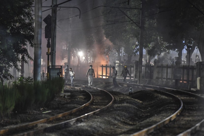 Pelajar dan mahasiswa berjalan di sepanjang rel kereta api saat melakukan aksi unjuk rasa di belakang gedung MPR/DPR, Jalan Tentara Pelajar, Jakarta, Senin (30/9/2019). 