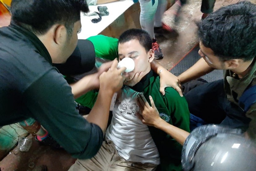 Mahasiswa peserta demonstrasi di sekitar Kompleks Parlemen Senayan diberikan pertolongan pertama oleh relawan tim medis di Pos Polsi di Depan Hotel Sultan, Jakarta, Senin (30/9).