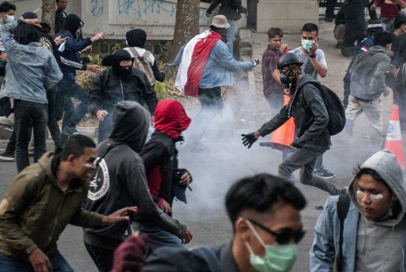 Mahasiswa dan pelajar bentrok dengan petugas kepolisian usai unjuk rasa di depan gedung DPRD Jawa Barat, Bandung, Jawa Barat, Senin (30/9/2019).