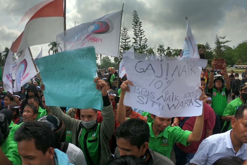 Massa Konfederasi Serikat Buruh Sejahtera Indonesia (KSBSI) membawa poster berisi tuntutan saat unjuk rasa tarif BPJS Kesehatan di Kantor DPRD Provinsi Jambi, Jambi, Senin (30/9/2019). 