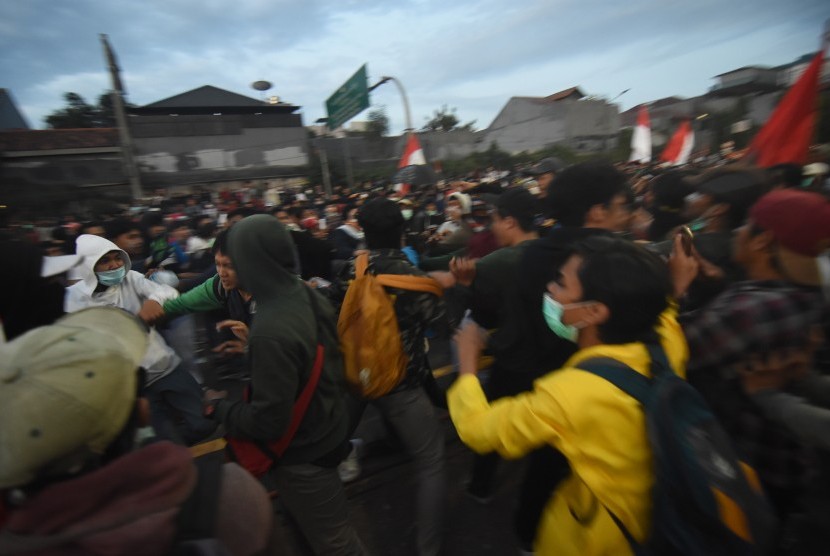 Sejumlah mahasiswa menghalau massa yang terlibat bentrok dengan polisi saat aksi unjuk rasa di depan gedung Parlemen, Jakarta, Senin (30/9/2019).