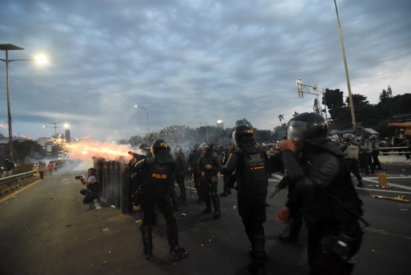 Polisi menembakkan gas air mata ke arah pengunjuk rasa di Jalan Gatot Subroto, Jakarta, Senin (30/9/2019).