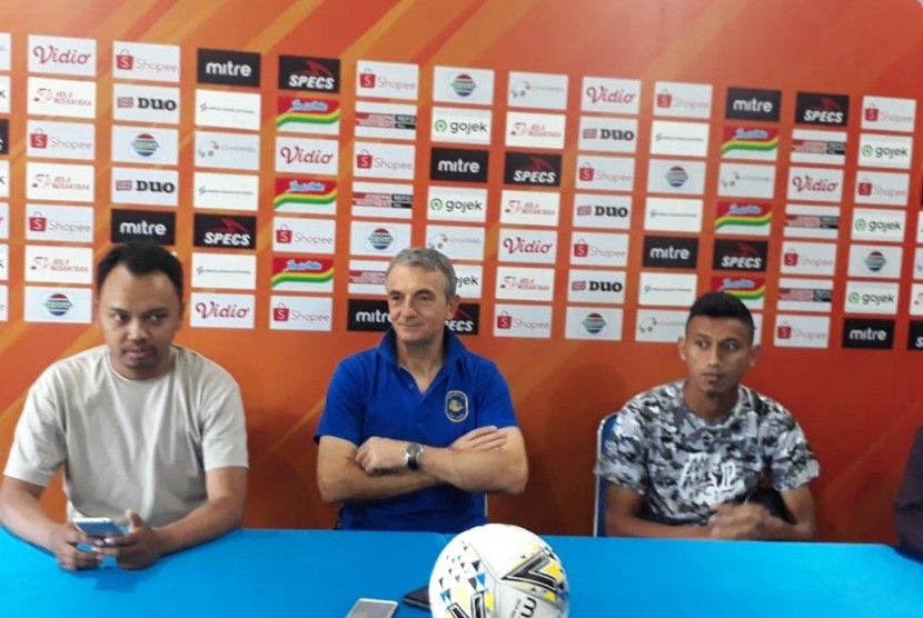 Pelatih Arema FC, Milomir Seslija (tengah) dan pemain Rivaldi Bauwo (kanan) memberikan keterangan pers terkait persiapan pertandingan melawan PSM Makassar di Kantor Arema FC, Kota Malang, Selasa (1/10). 