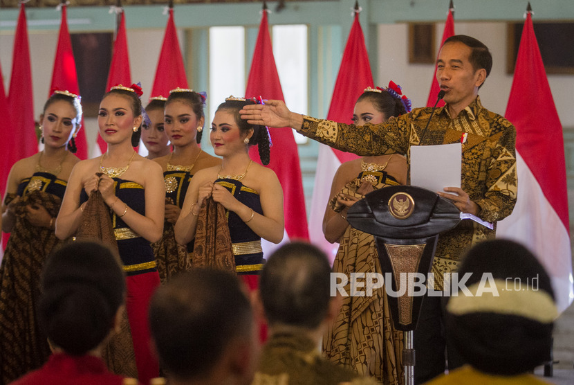 Presiden Joko Widodo (kanan) memberikan sambutan pada peringatan Hari Batik Nasional 2019 di Pura Mangkunegaran, Solo, Jawa Tengah, Rabu (2/10/2019). 
