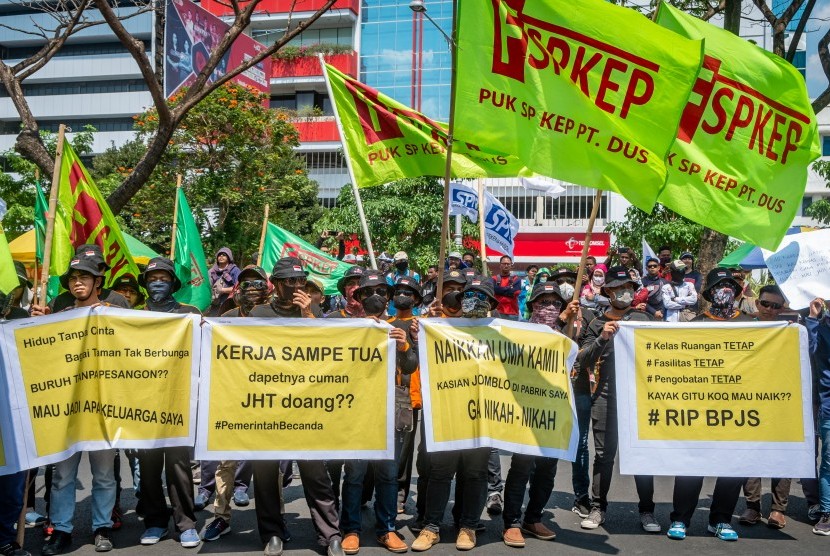 Sejumlah buruh dari berbagai serikat buruh di Jawa Tengah membawa poster saat berunjuk rasa di depan Kantor Gubernur Jawa Tengah di Semarang, Jawa Tengah, Rabu (2/10/2019).