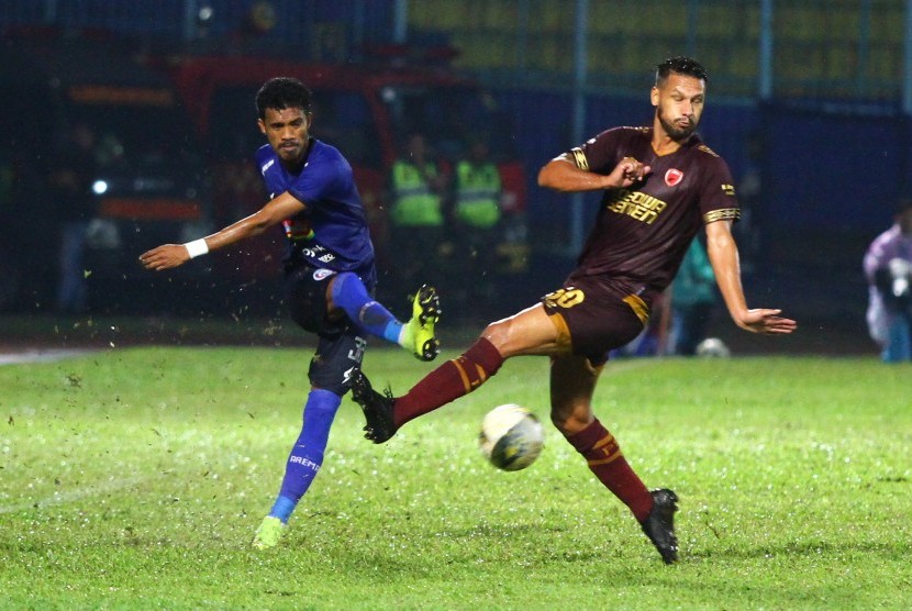 Pesepak bola PSM Makassar, Raphael Maitimo (kanan) berusaha menghalangi bola yang ditendang pesepak bola Arema FC, Alfin Tualasamony (kiri) dalam pertandingan Liga I di Stadion Kanjuruhan, Malang, Jawa Timur, Rabu (2/10/2019). 