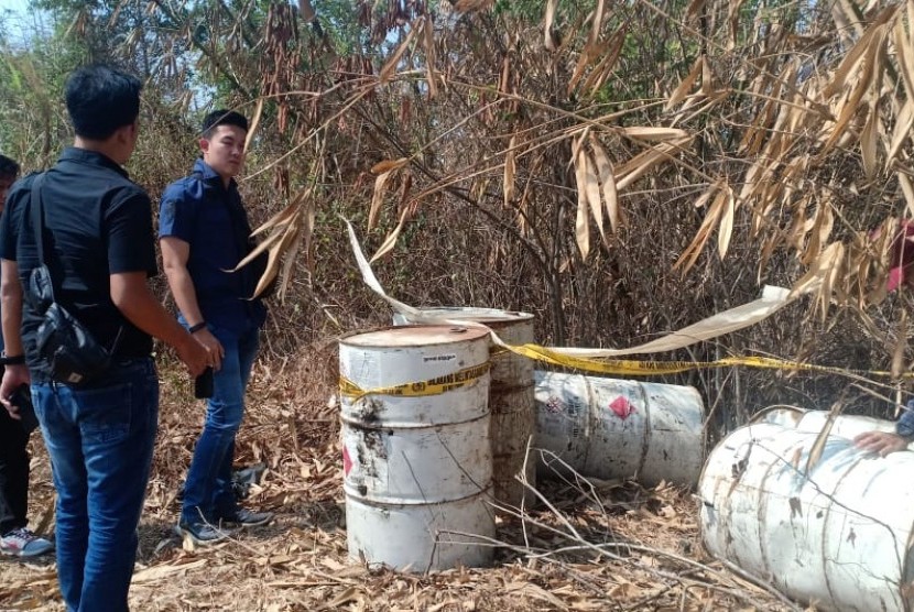 Tim Tipiter Satreskrim Polres Karawang, menyelidiki belasan drum tak bertuan diduga berisi limbah cair B3 yang dibuang di hutan milik Perhutani, Kamis (3/10).