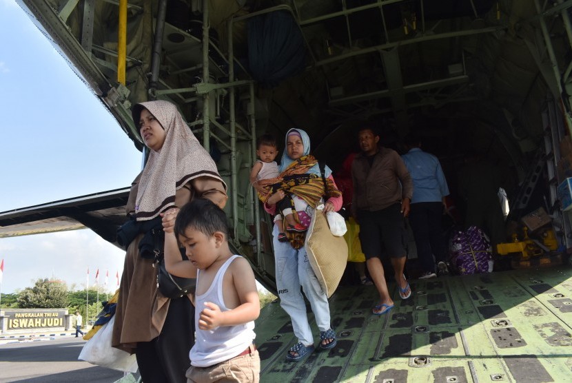 Para pengungsi akibat kerusuhan Wamena turun dari Pesawat Hercules C-130 TNI AU saat transit di Lanud Iswahjudi Magetan, Jawa Timur, Kamis (3/10/2019).