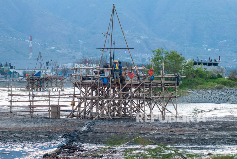 Sejumlah pekerja melakukan pengeboran untuk mengetahui struktur lapisan tanah pemancangan tiang penyangga pembangunan kembali Jembatan Kuning Palu, Sulawesi Tengah, Ahad (6/10/2019). 