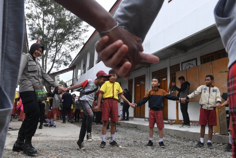 Seorang anggota Polisi wanita bermain dengan siswa SD di Kota Wamena, Kabupaten Jayawijaya, Papua (ilustrasi).