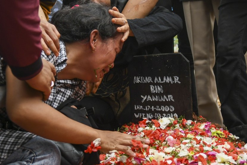Ibu Akbar Alamsyah, Rosminah (kiri) menangis saat prosesi pemakaman korban demo ricuh Akbar Alamsyah di Taman Pemakaman Umum (TPU) kawasan Cipulir, Kebayoran Lama, Jakarta, Jumat (11/10/2019). 