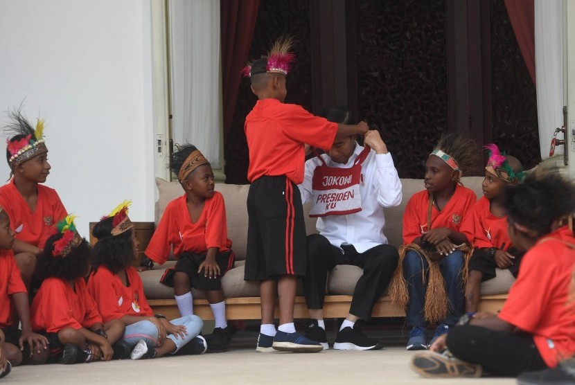 Presiden Joko Widodo menerima noken pemberian anak-anak perwakilan siswa SD di Jayapura dan Asmat, Papua, di Istana Merdeka, Jakarta, Jumat (11/10/2019).
