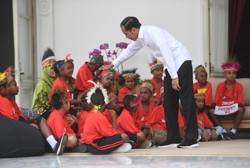 Presiden Joko Widodo berjabat tangan dengan anak-anak perwakilan siswa SD di Jayapura dan Asmat, Papua, di Istana Merdeka, Jakarta, Jumat (11/10/2019).