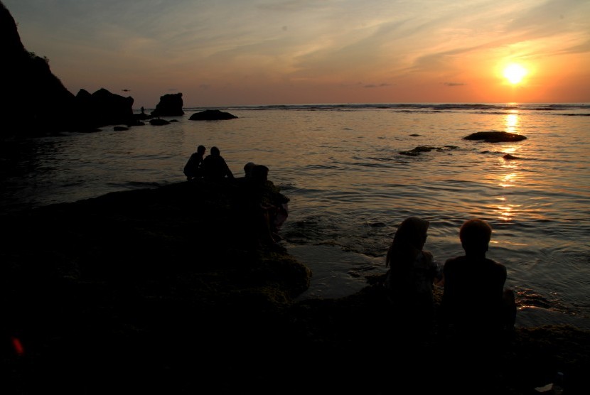 Wisatawan lokal dan asing menikmati panorama sunset di Pantai Uluwatu, Bali, Ahad (12/10/2019).