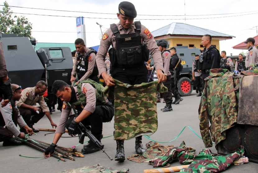 Petugas kepolisian menyita sejumlah atribut dan senjata tajam ketika membongkar Markas Komite Nasional Papua Barat (KNPB) di Timika, Papua, Senin (14/10/2019).