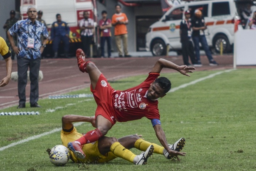 Pesepak bola Persija Jakarta Ramdani Lestaluhu (kanan) berebut bola dengan Pesepak bola Semen Padang FC Vanderley (bawah) pada lanjutan Liga 1 di Stadion Patriot Chandrabahaga, Bekasi, Jawa Barat, Rabu (16/10/2019).