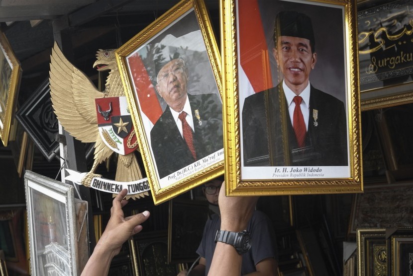 Pengunjung mengamati poster Presiden Joko Widodo dan Wakil Presiden terpilih Ma'ruf Amin di salah satu kios figura di Sriwedari, Solo, Jawa Tengah, Rabu (16/10/2019).