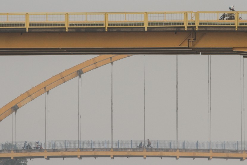 Sejumlah pengendara melintas di atas jembatan Siak I dan III ketika kabut asap tipis kembali menyelimuti Pekanbaru, Riau, Rabu (16/10/2019).