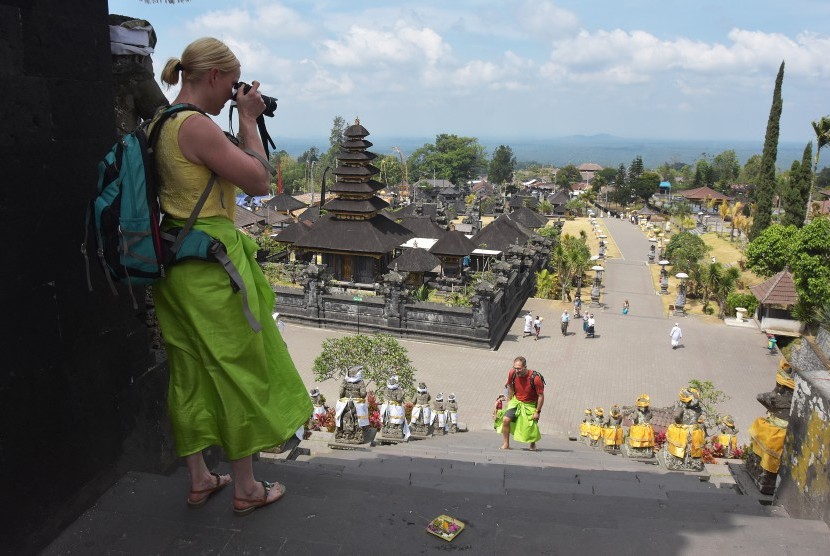 Wisatawan mancanegara memotret suasana kawasan Pura Besakih di Karangasem, Bali, Kamis (17/10/2019). Badan Pusat Statistik (BPS) mencatat kunjungan wisatawan mancanegara ke Indonesia naik 0,95 persen pada Juli 2020 