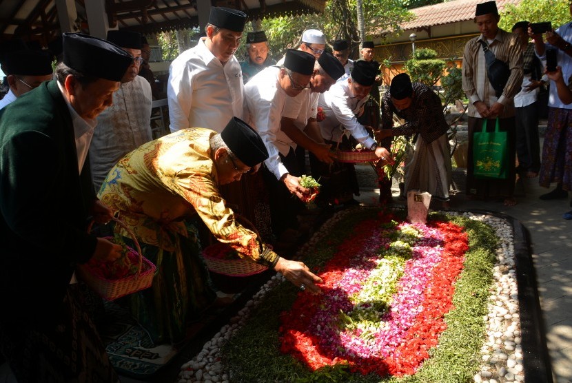 Ketua Umum PBNU KH Said Aqil Siroj (kedua kiri) menaburkan bunga di atas makam Gus Dur di Ponpes Tebuireng, Jombang, Jawa Timur, Kamis (17/10/2019).